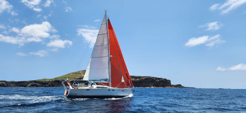 Voilier qui fait un tour du monde à la voile naviguant dans les eaux bleues